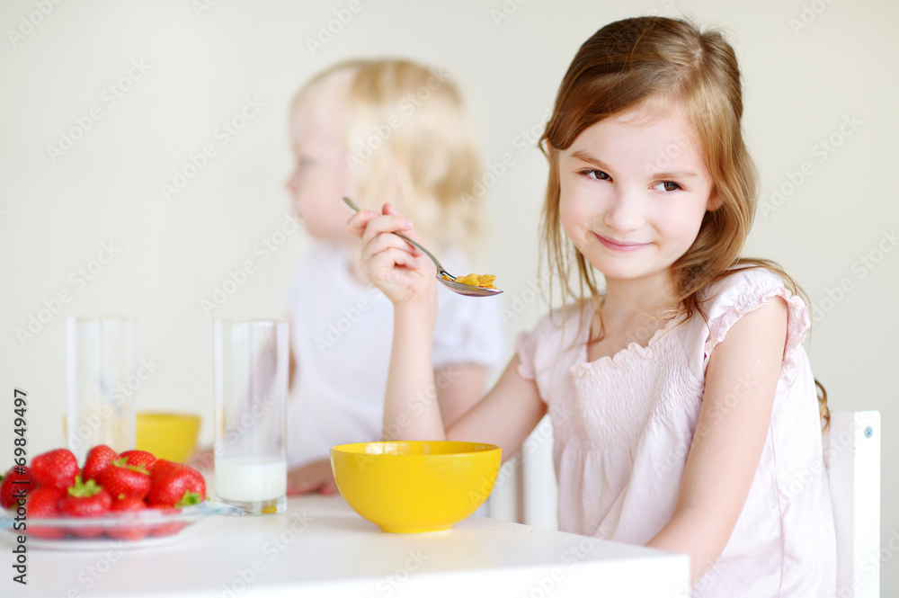 Two sisters eating cereal with milk Two sisters eating cereal with milk