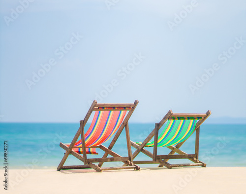 Bright color wooden beach chairs on island tropical beach © Joshhh
