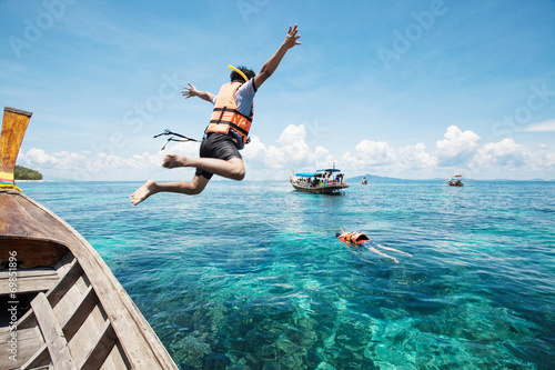 Snorkeling divers jump in the water photo