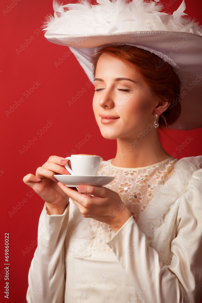 Portrait of redhead edwardian women with cup on red background. Portrait of redhead edwardian women with cup on red background.