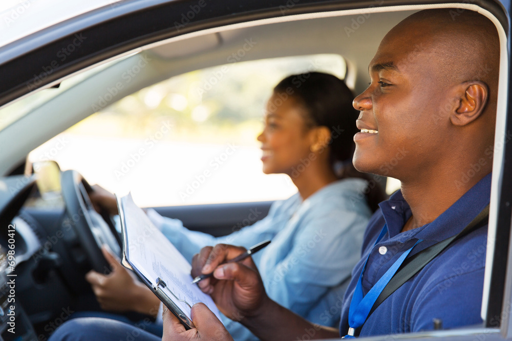 © michaeljung - african american driving instructor inside a car