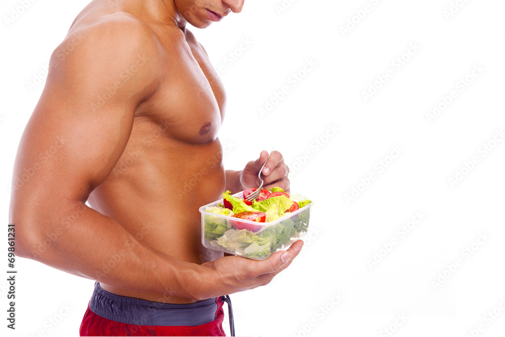 Muscular man holding a bowl of fresh salad on a white background Muscular man holding a bowl of fresh salad on a white background