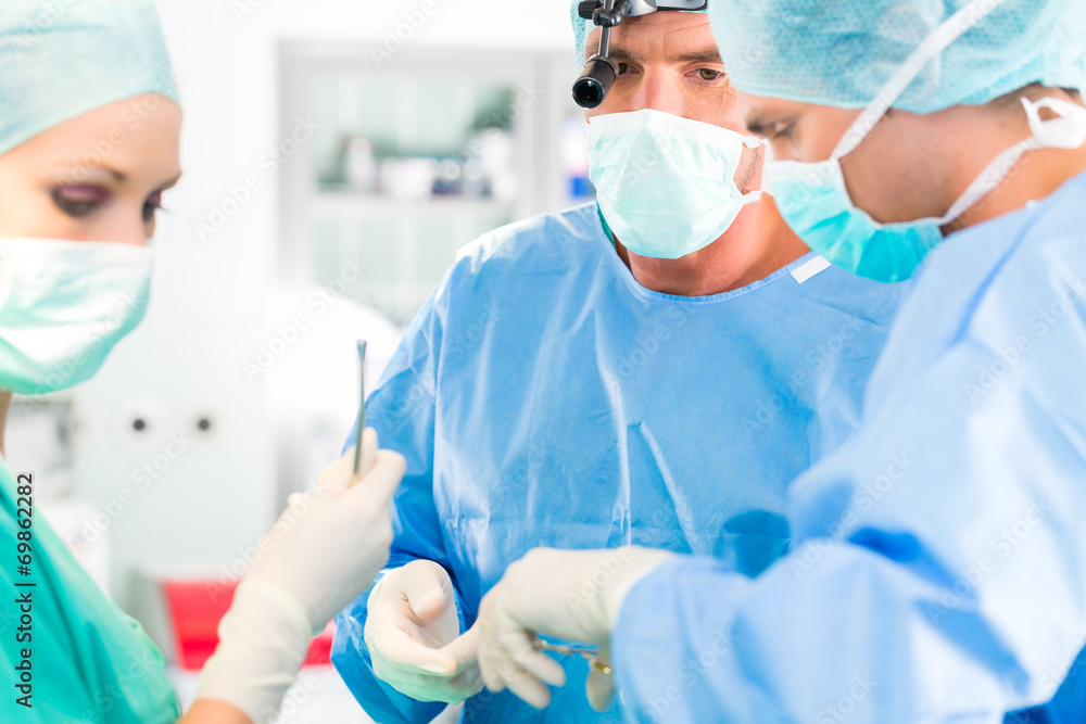 Surgeons operating patient in operation theater Surgeons operating patient in operation theater