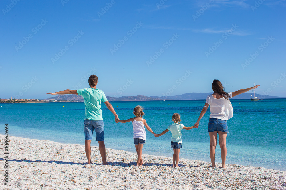 Young beautiful family with two kids on tropical vacation