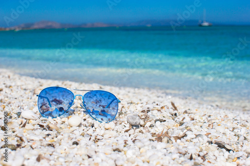 Close up of colorful blue sunglasses on tropical beach