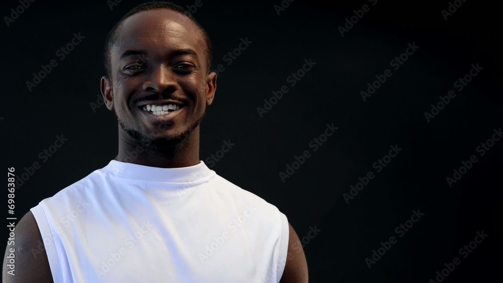 Afro-american sport man on black background smiling Afro-american sport man on black background smiling