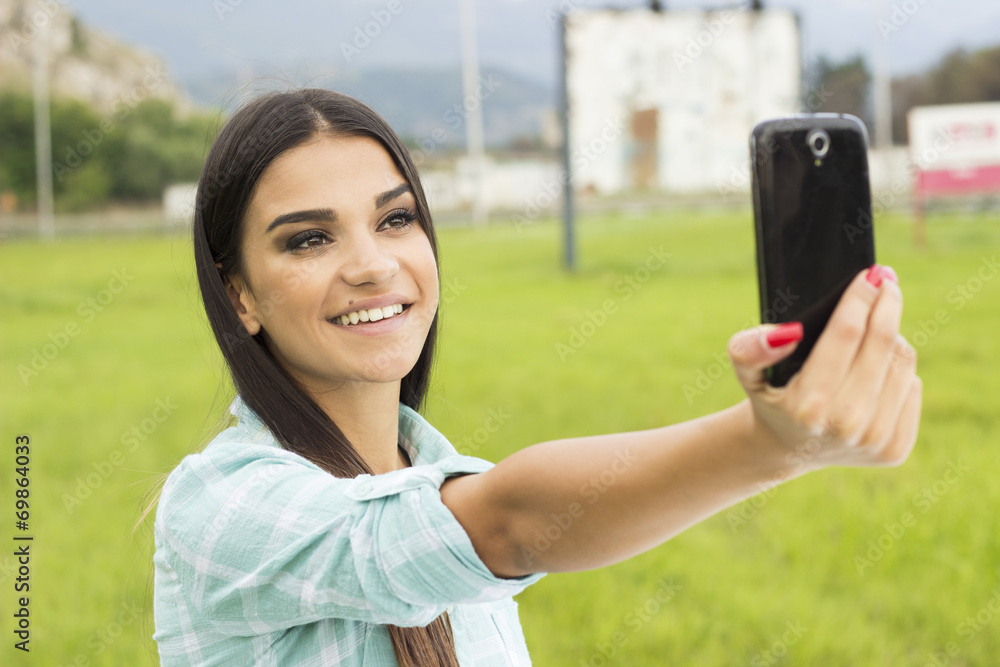 Portrait young girl taking selfies with her smart phone in park Portrait young girl taking selfies with her smart phone in park