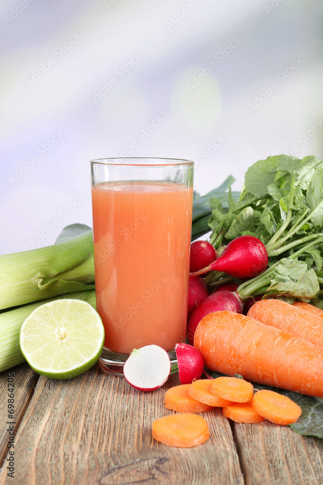 Fresh carrot juice with vegetables on wooden table Fresh carrot juice with vegetables on wooden table