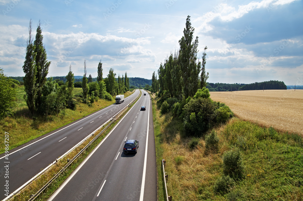The rural landscape with a highway leading poplar alley