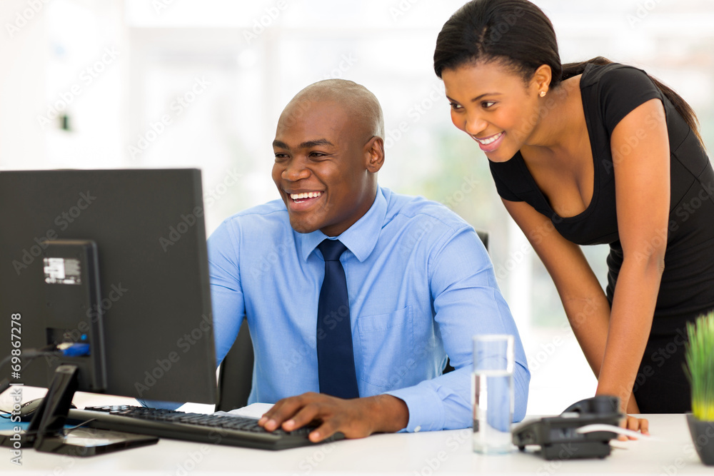african secretary with her boss working on computer