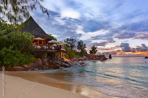 Cafe on Seychelles tropical beach at sunset photo