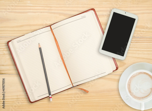 notebook with pencil, smart phone and coffee cup on wooden backg