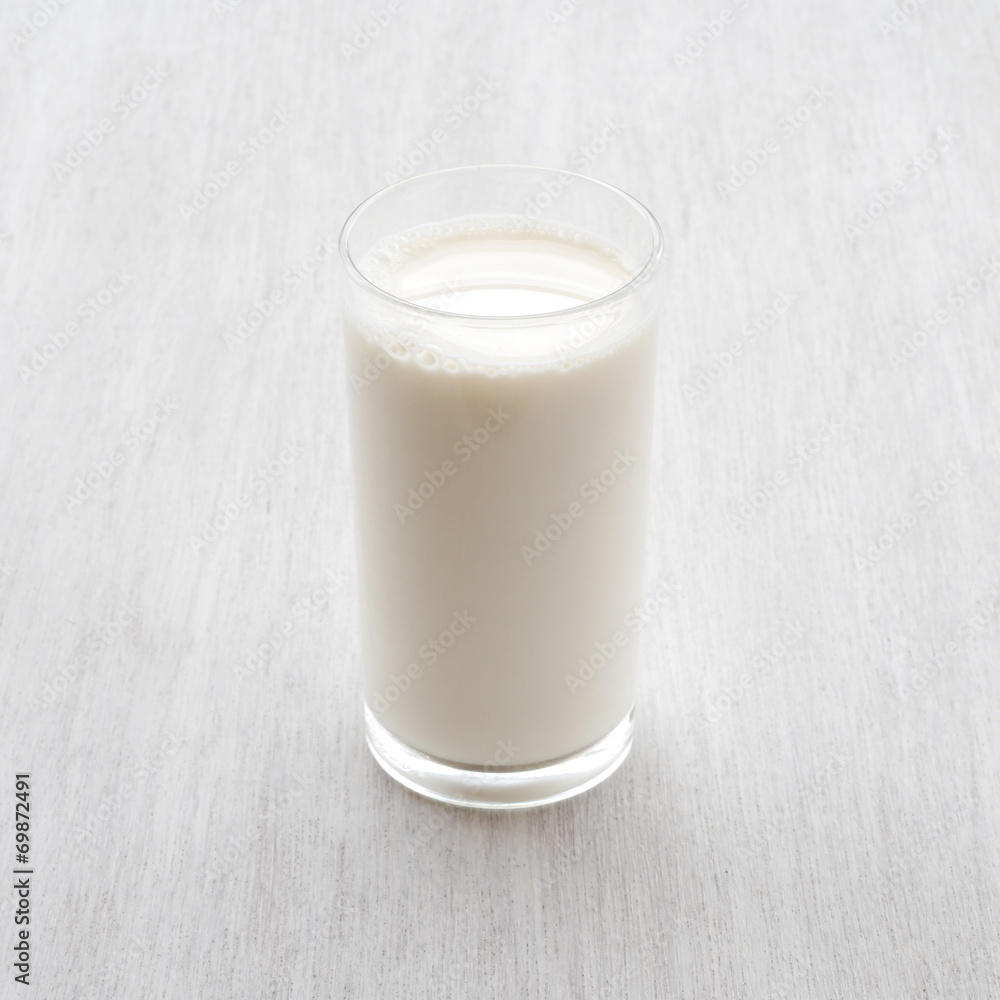 Glass of milk on white wooden floor Glass of milk on white wooden floor