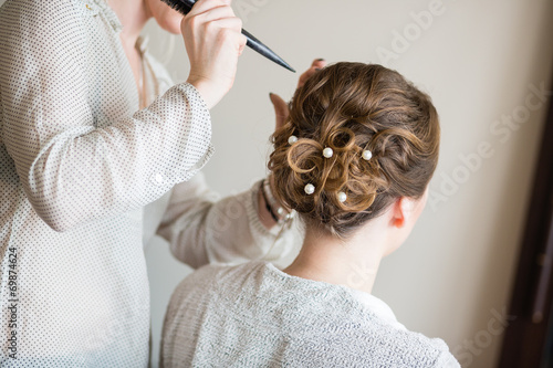 Bride getting her hair done before wedding