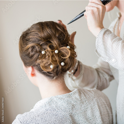 Bride getting her hair done before wedding