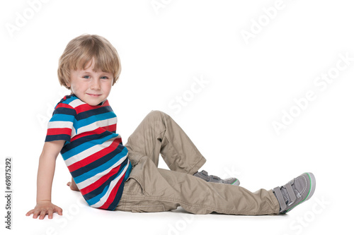 Preschool boy sits on the floor