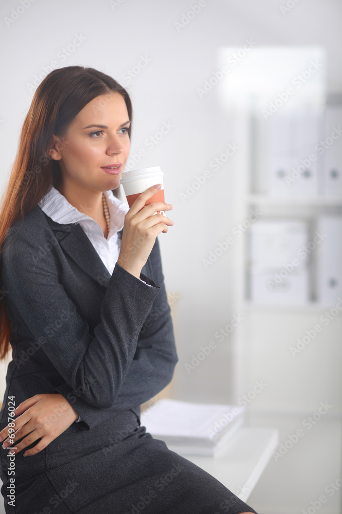 Woman drink coffee at office, standing near desk Woman drink coffee at office, standing near desk