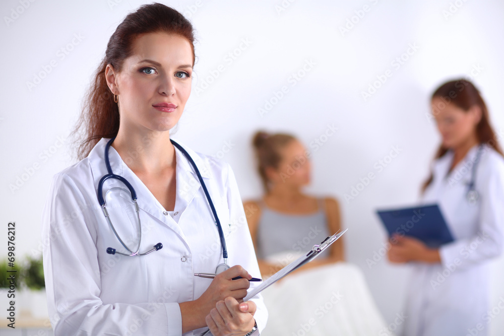Smiling female doctor with a folder in uniform standing at Smiling female doctor with a folder in uniform standing at
