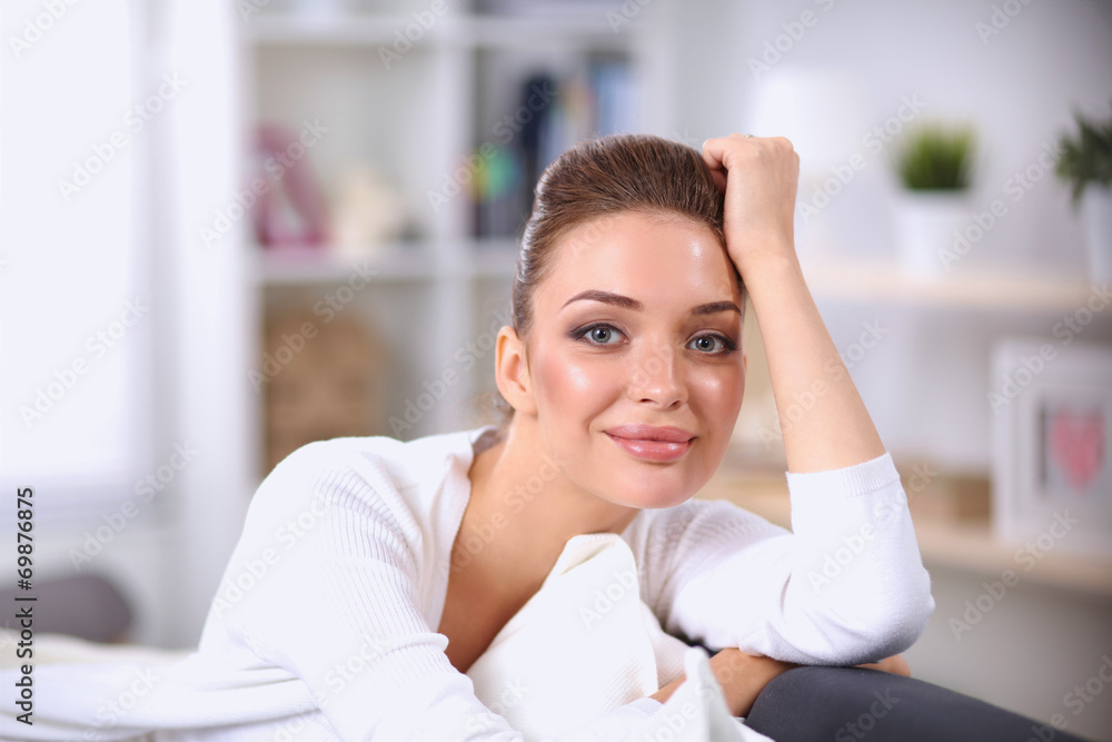 Young beautiful woman sitting on couch at her room Young beautiful woman sitting on couch at her room