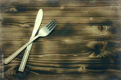Fotografiet Knife and fork set on a wooden vintage table