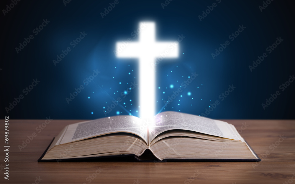 Open holy bible with glowing cross in the middle Open holy bible with glowing cross in the middle