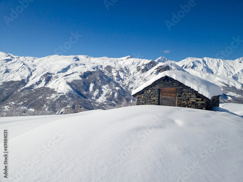 Picturesque traditional cabin in the Alps in winter © Delphotostock
