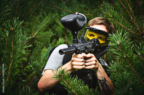 Paintball player hides in the woods photo