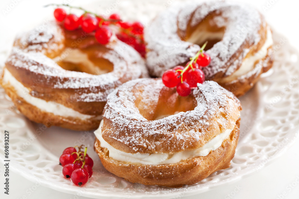 Cream puff rings decorated with fresh red currant Cream puff rings decorated with fresh red currant