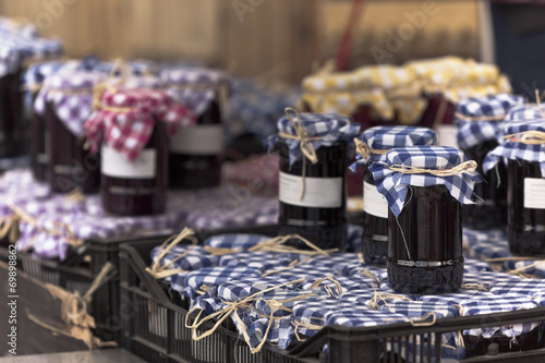Fototapeta Naklejka Na Ścianę i Meble -  Many preserving jars with dark jam in a market