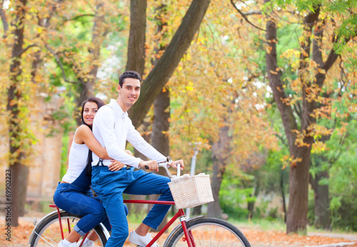 Teen couple with bike in the park in autumn time