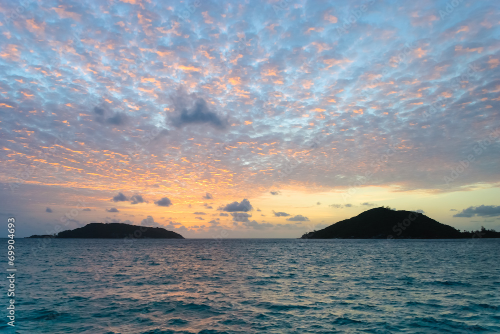 Scenic view of sunset with clouds and two Seychelles islands
