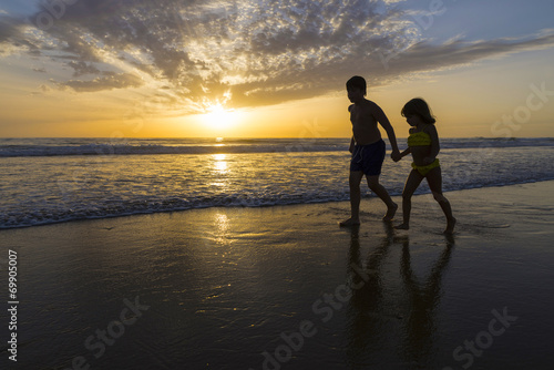 Children bathing on the beach at dusk