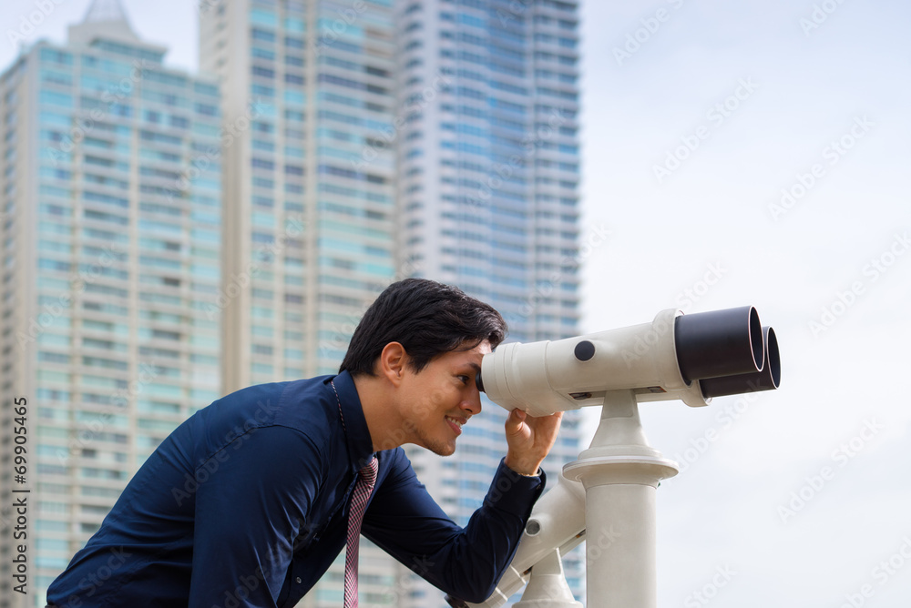 Asian business man with binoculars looking at city