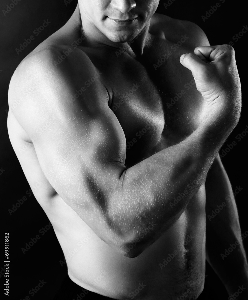 Sexy muscular man on dark background in shades of grey Sexy muscular man on dark background in shades of grey