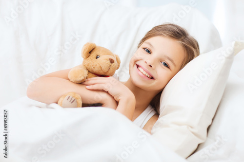 little girl with teddy bear sleeping at home
