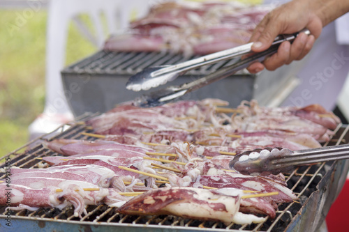 Seafood barbecue of grilled squids on gridiron charcoal stove