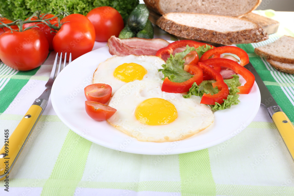 Scrambled eggs with bacon and vegetables served Scrambled eggs with bacon and vegetables served