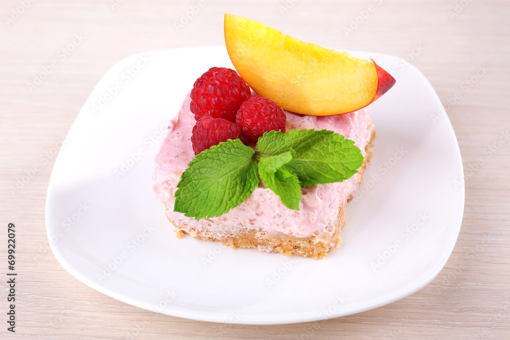 Cake with fruits and berries on plate on wooden background