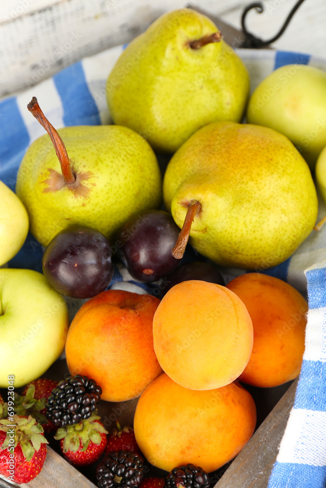 Ripe fruits and berries on wooden tray on table close up Ripe fruits and berries on wooden tray on table close up