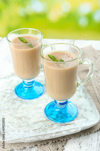 Delicious berry mousse in glasses on table on bright background