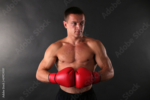 Handsome young muscular sportsman with boxing gloves