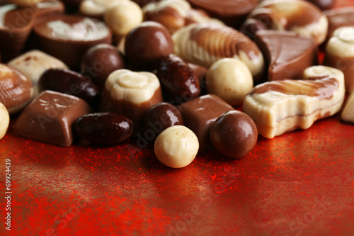 Different kinds of chocolates on red background