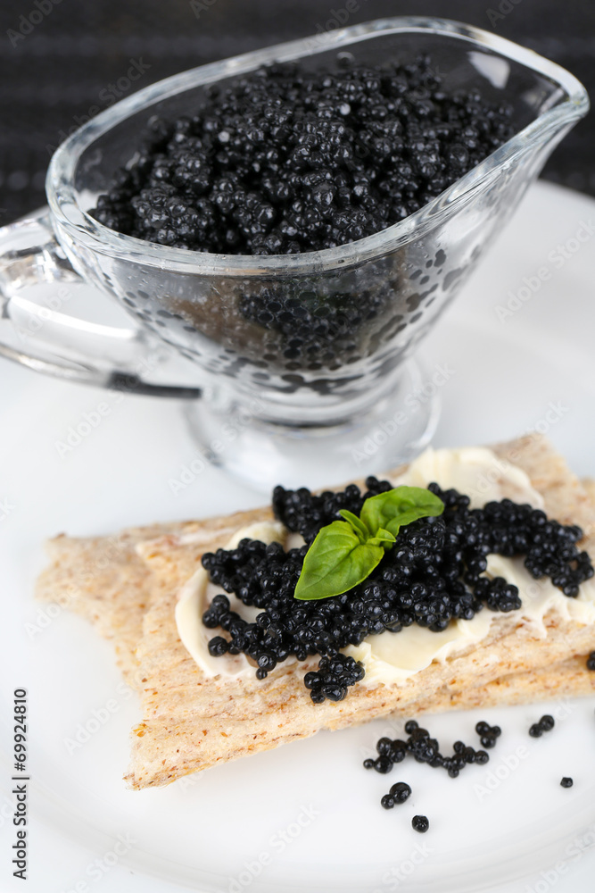 Slice of bread with butter and sauceboat with caviar Slice of bread with butter and sauceboat with caviar