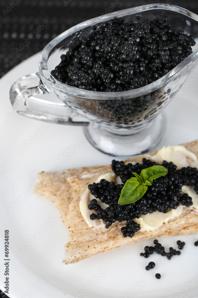 Slice of bread with butter and sauceboat with caviar Slice of bread with butter and sauceboat with caviar