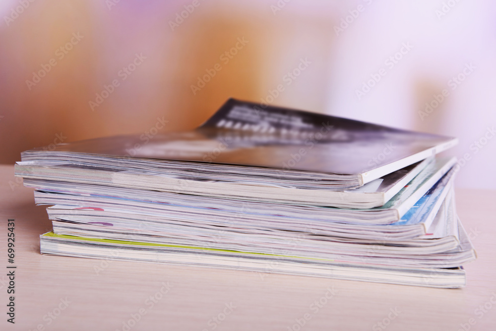 Magazines on wooden table on bright background Magazines on wooden table on bright background