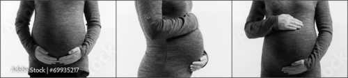 pregnant woman touching her belly with hands on white background photo