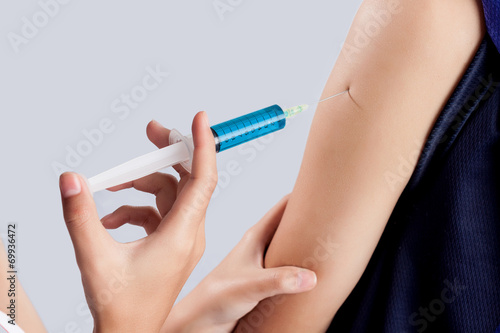 Injection in arm on white background