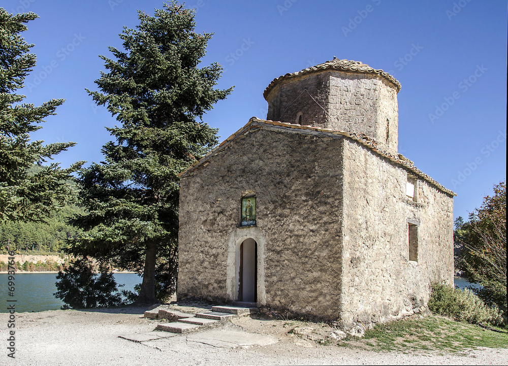 Greek small ancient chapel on a mountainous lake
