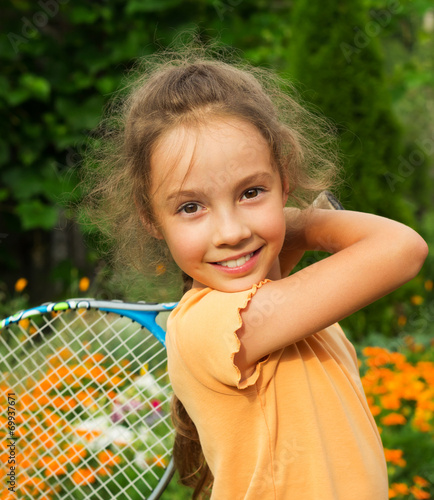 portrait of cute little girl playing tennis in summer