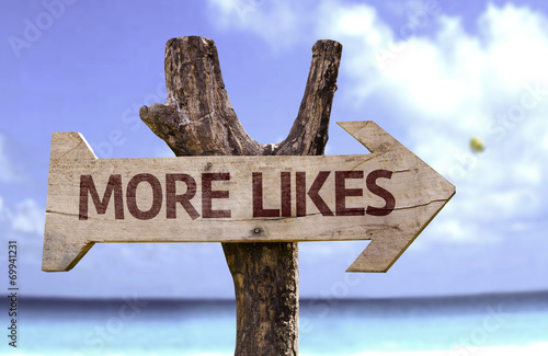 More Likes wooden sign with a beach on background